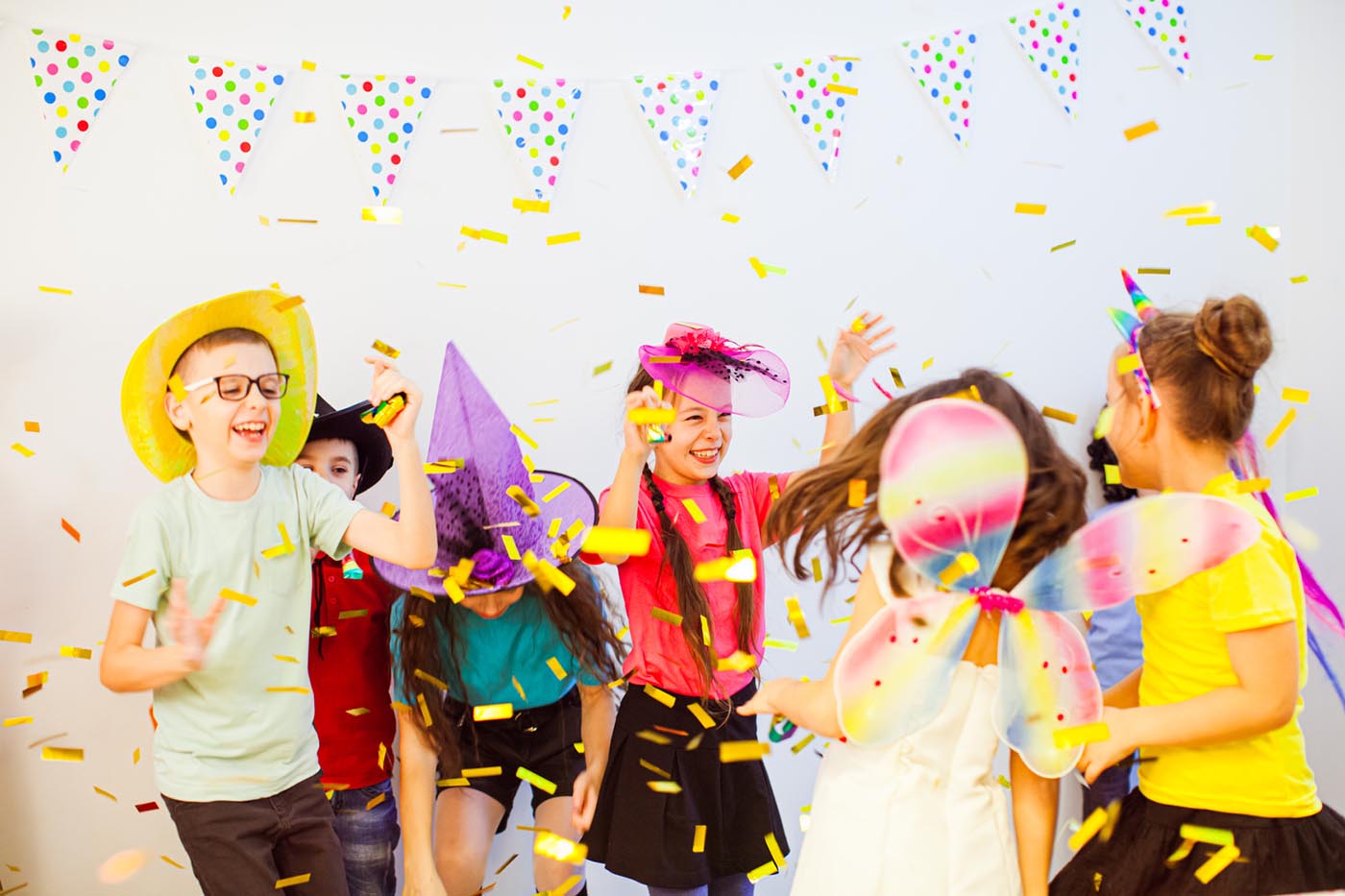 Children in party hats dancing together
